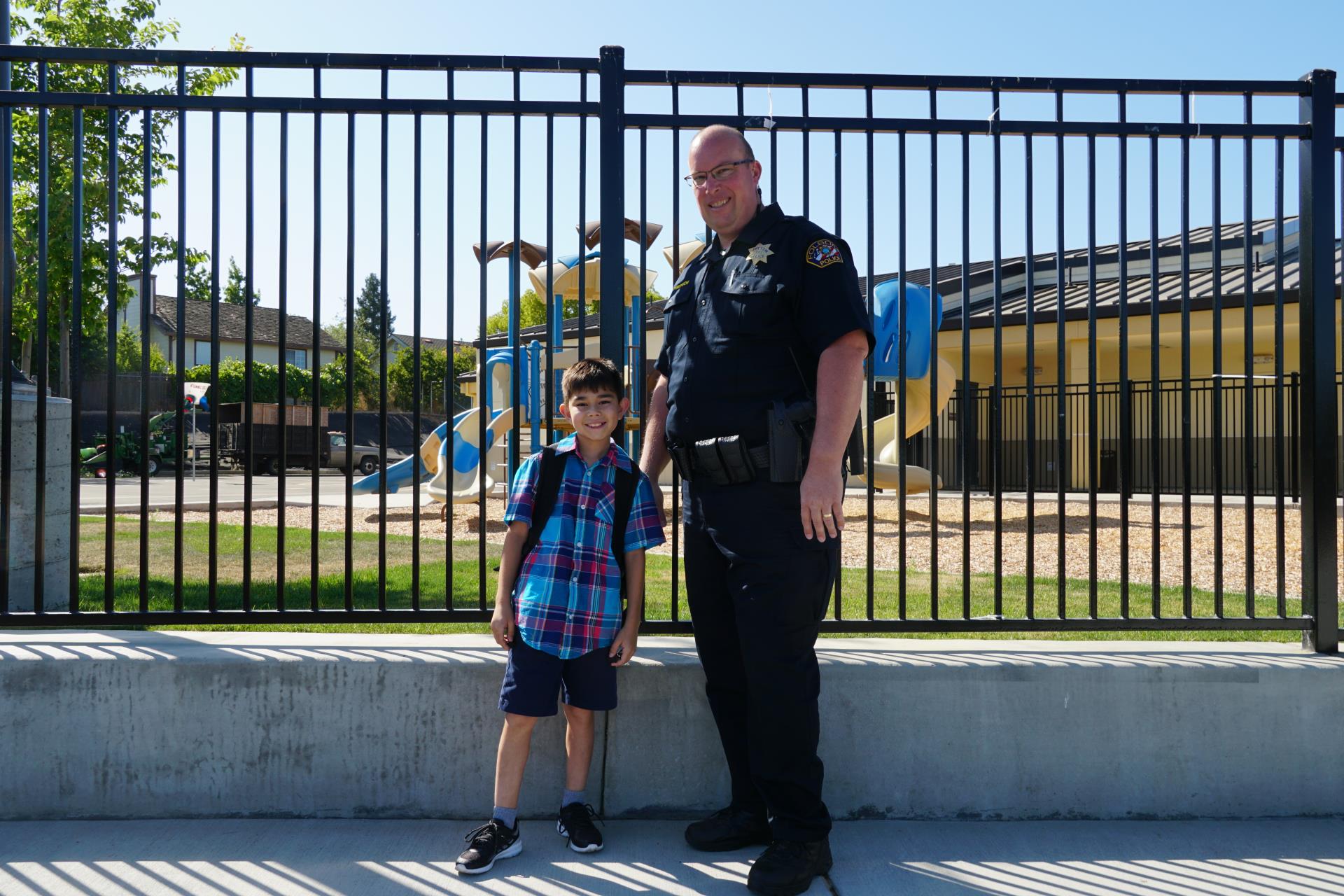 Officer with boy in front of school