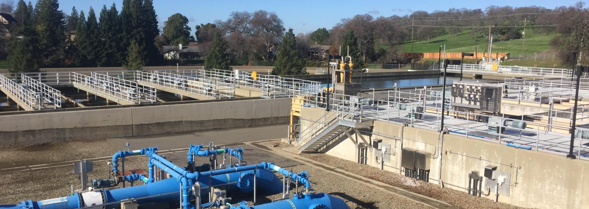 view across water treatment plant facility showing equipment and treatment ponds