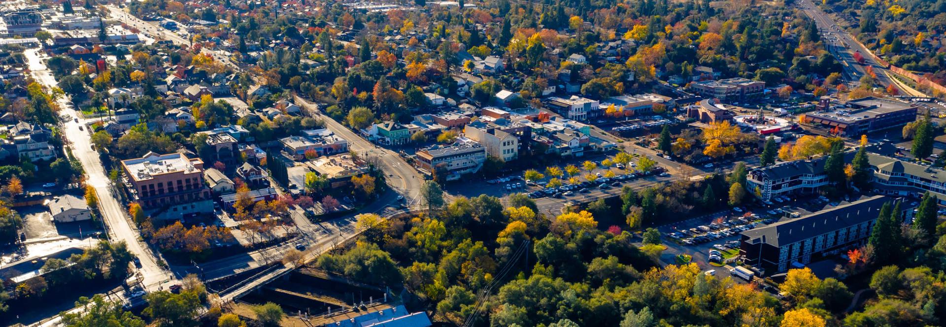Aerial of the Folsom Historic District. Several businesses, neighborhoods, and streets filled with fall colored trees and cars.