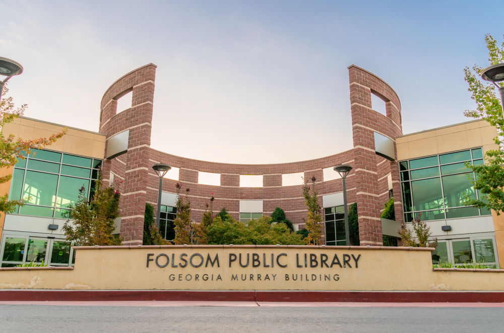 10-11-2018 Library image of exterior of a light blue sky with some cloudines, showing the entrance sign of the library that states 