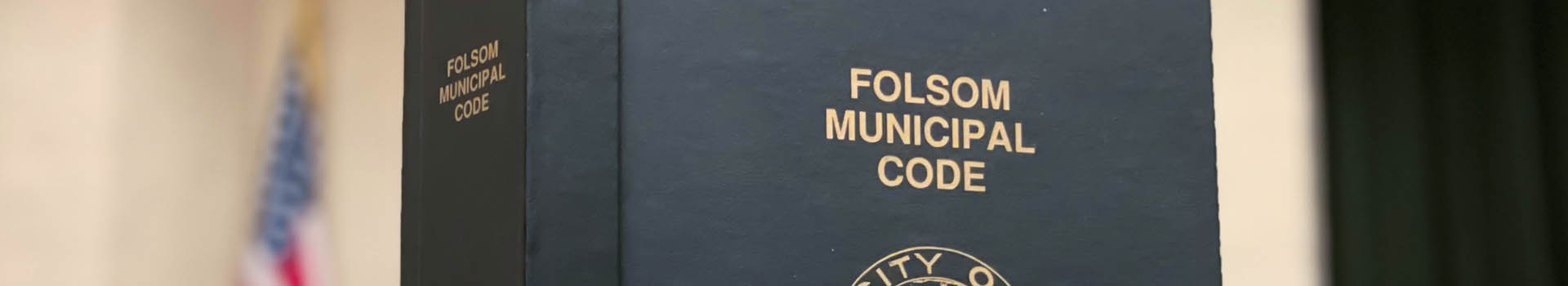 Attorney Banner of Folsom Municipal Code Black Book with Good Lettering and an American Flag in the background
