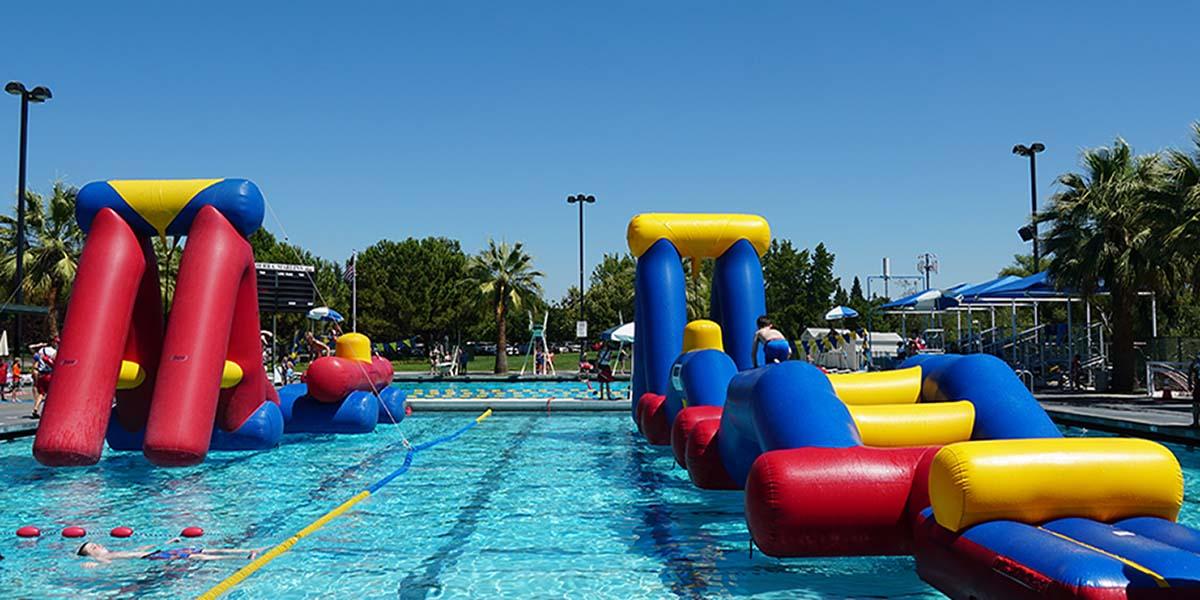 Giant Inflatables at the Folsom Aquatic Center in the pool with kids going on the course Photo