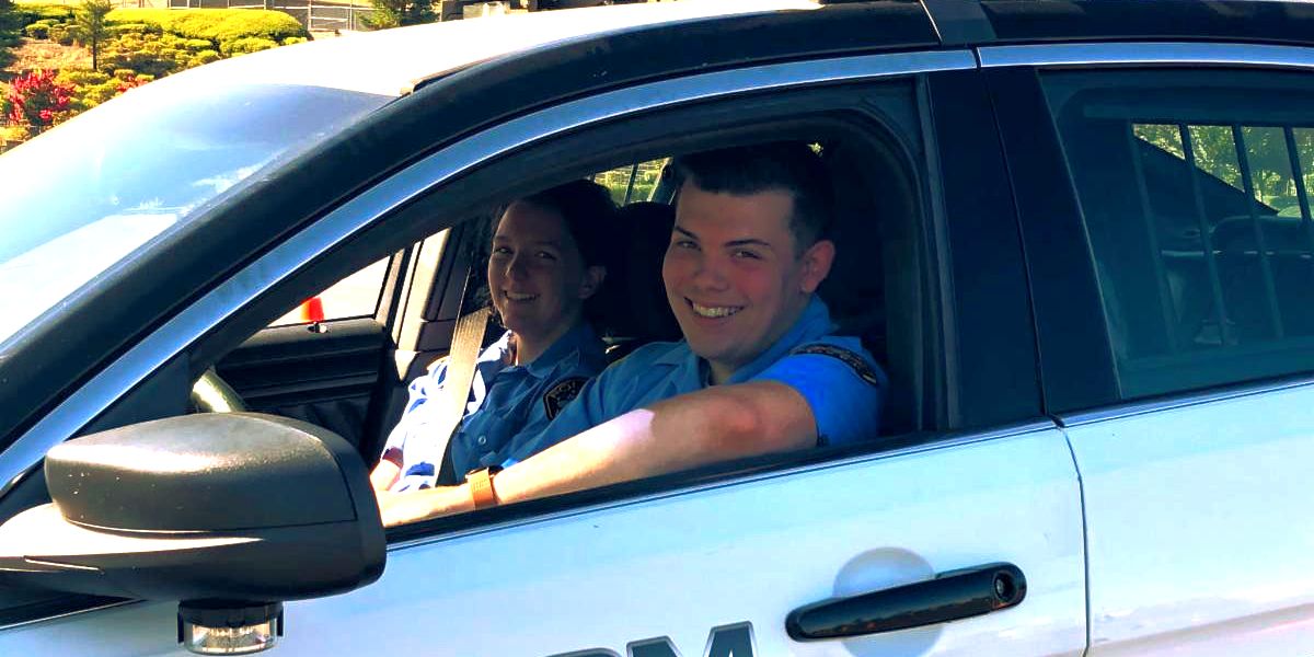folsom cadets in a police car smiling for the photo