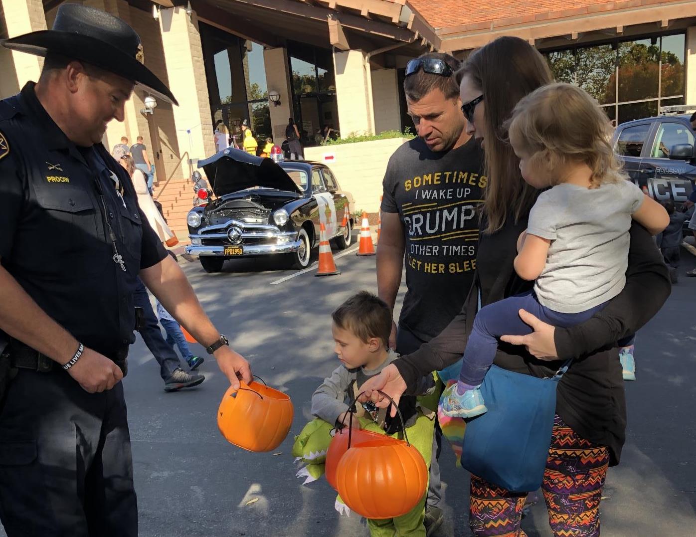 Police officer gives candy to family of trick or treaters