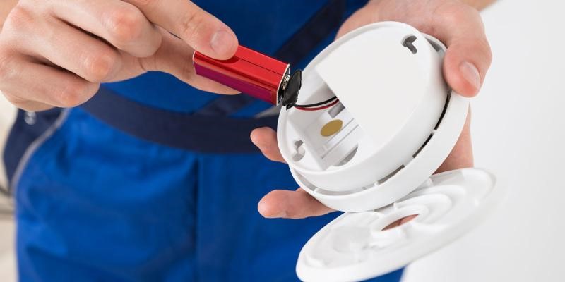 change clocks stock image of a worker in a blue uniform changing a red clock battery