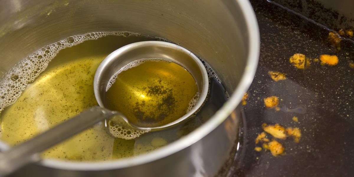 fat oil and grease picture of a ladle in a pot full of oil