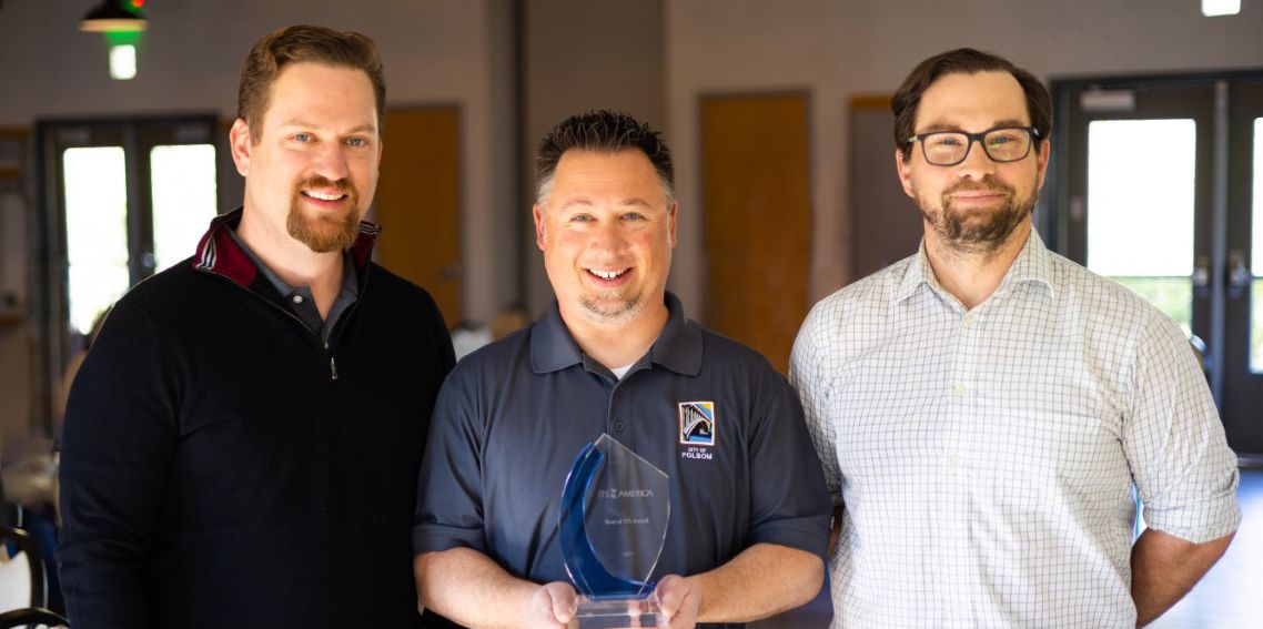 City of Folsom public works award with three employees, and the middle employee holding the blue and clear glass plaque award