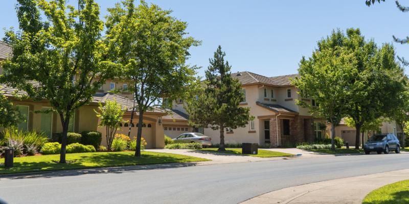 houses and street in folsom with a clean street, bright green grassy lawns, and trees