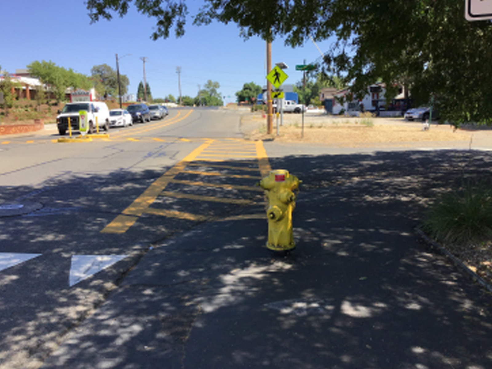 yellow fire hydrant with a yellow crosswalk in the background near Sutter Middle and cars in the background