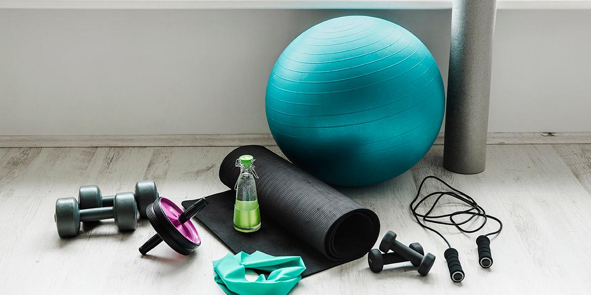 Senior Cardio Strength Class photo with workout equipment ona wooden floor, i.e. greeen water bottle, yoga mat, workout band, roller, 2 sets of dumbells, jump rope, and a workout ball