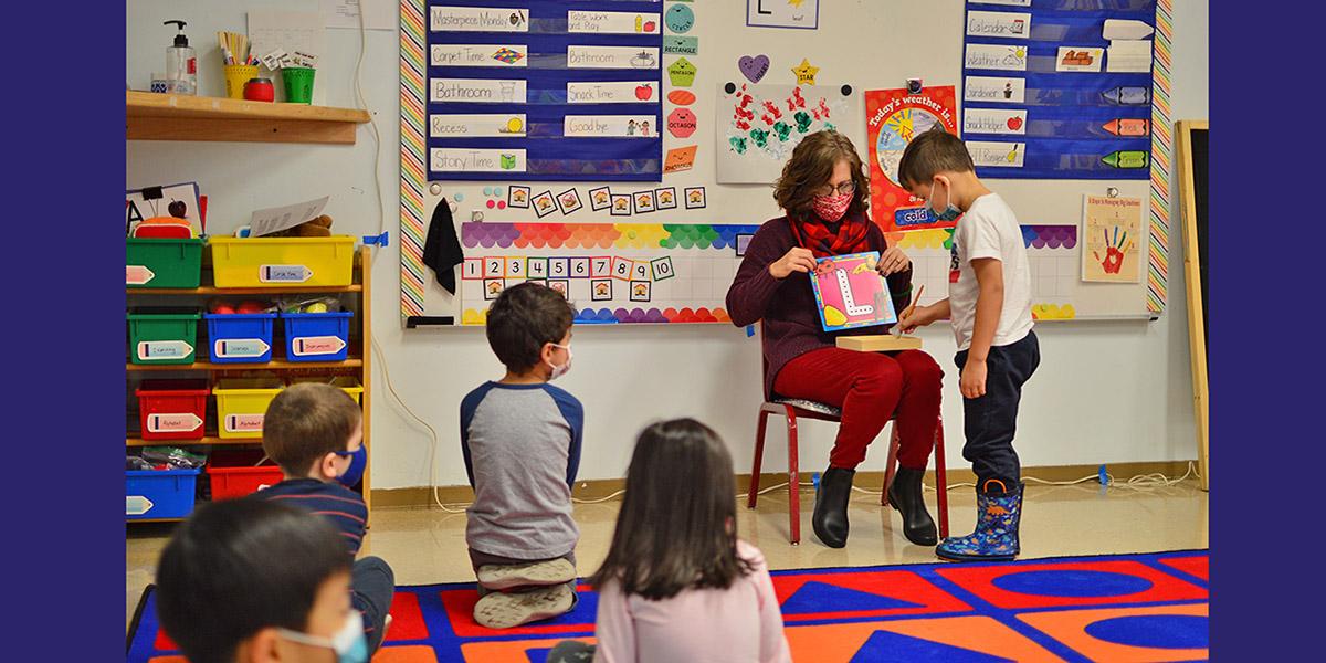 Preschool Classroom with students and teacher reading a book
