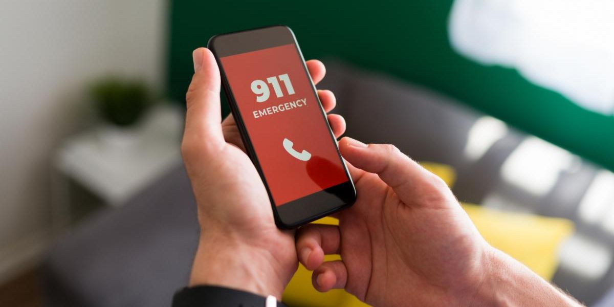 person's hands holding a mobile phone, dialing 911