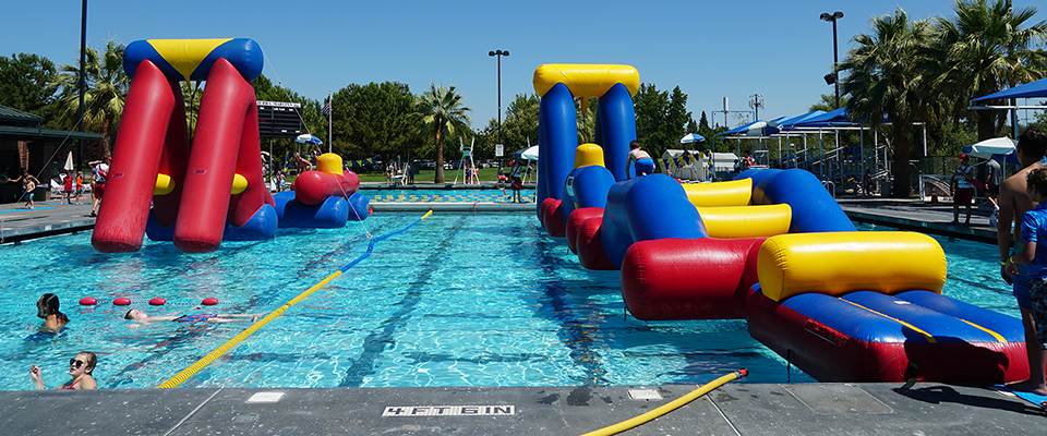 Two giant inflatable play structures floating in the 50 meter pool at the Steve Miklos Aquatic Center