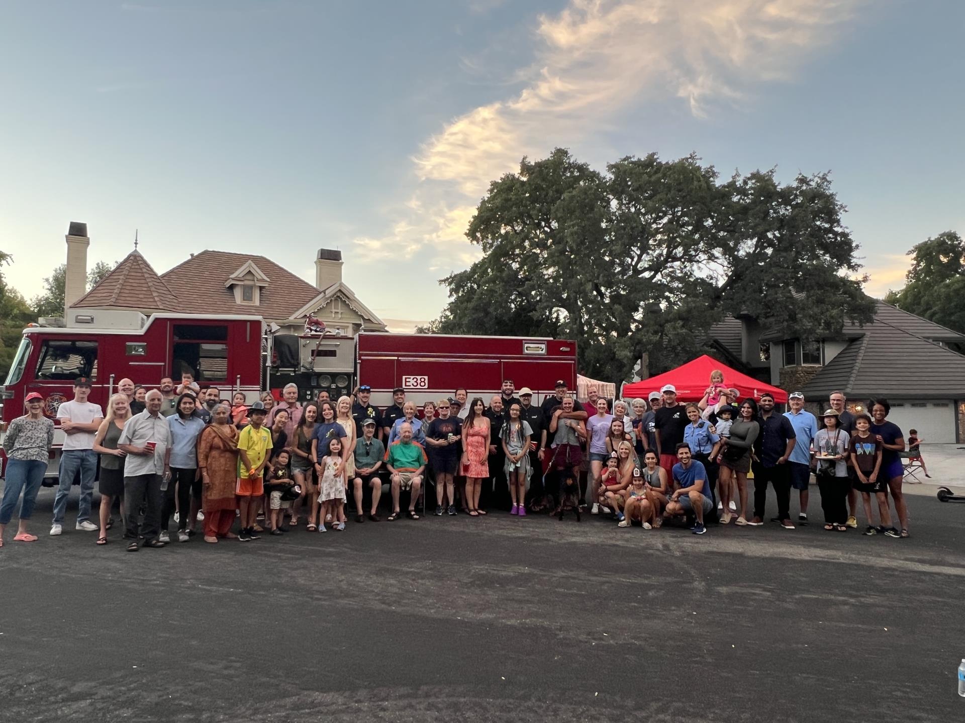 Neighborhood group with Folsom Police Officers and Firefighters in front of a Folsom Fire Truck