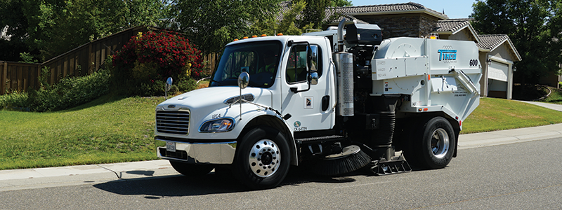 street sweeper vehicle cleaning the streets in a neighborhood