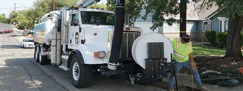 Stormwater Management page header of an employee with a truck cleaning out a drain